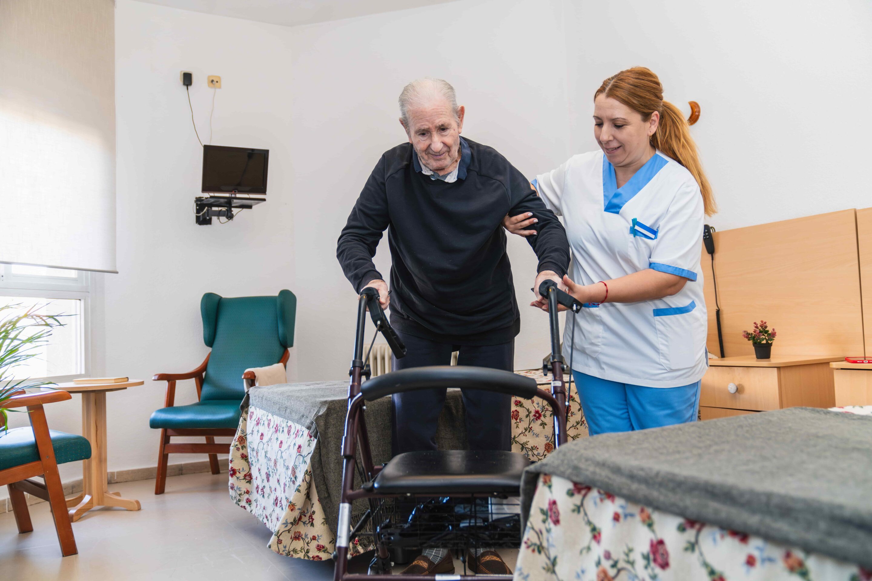 caring-nurse-assisting-elderly-man-with-walker-2025-03-08-21-09-46-utc-min-1-scaled.jpg